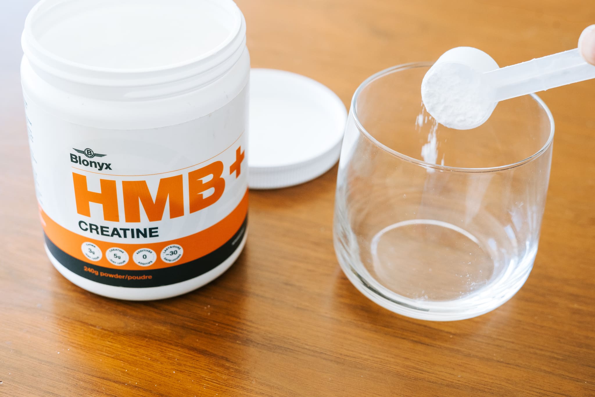 Blonyx HMB+ Creatine Being Scooped into a Glass