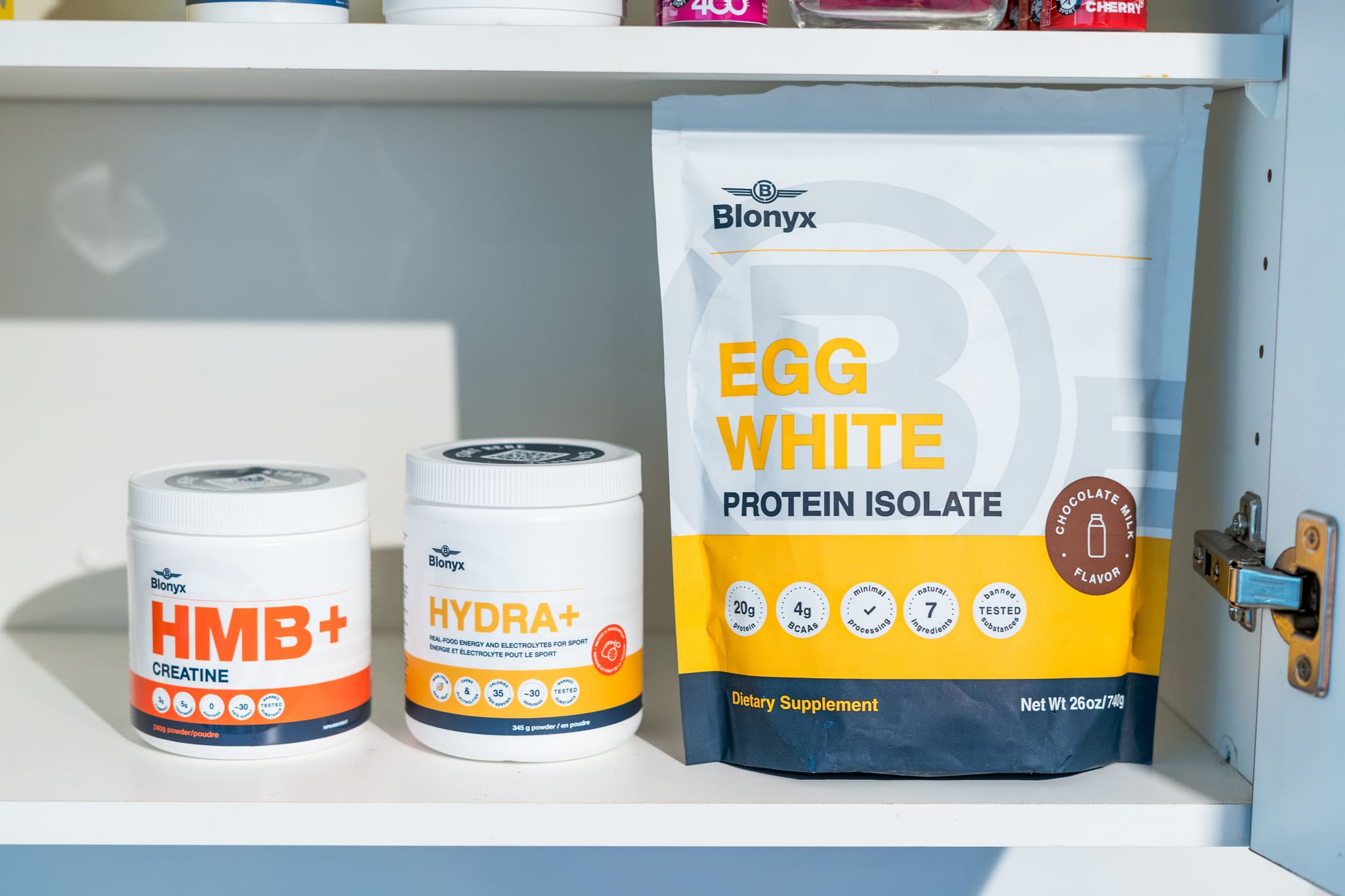Blonyx HMB+ Creatine, Hydra+, and Egg White Protein supplements are neatly displayed on a shelf.