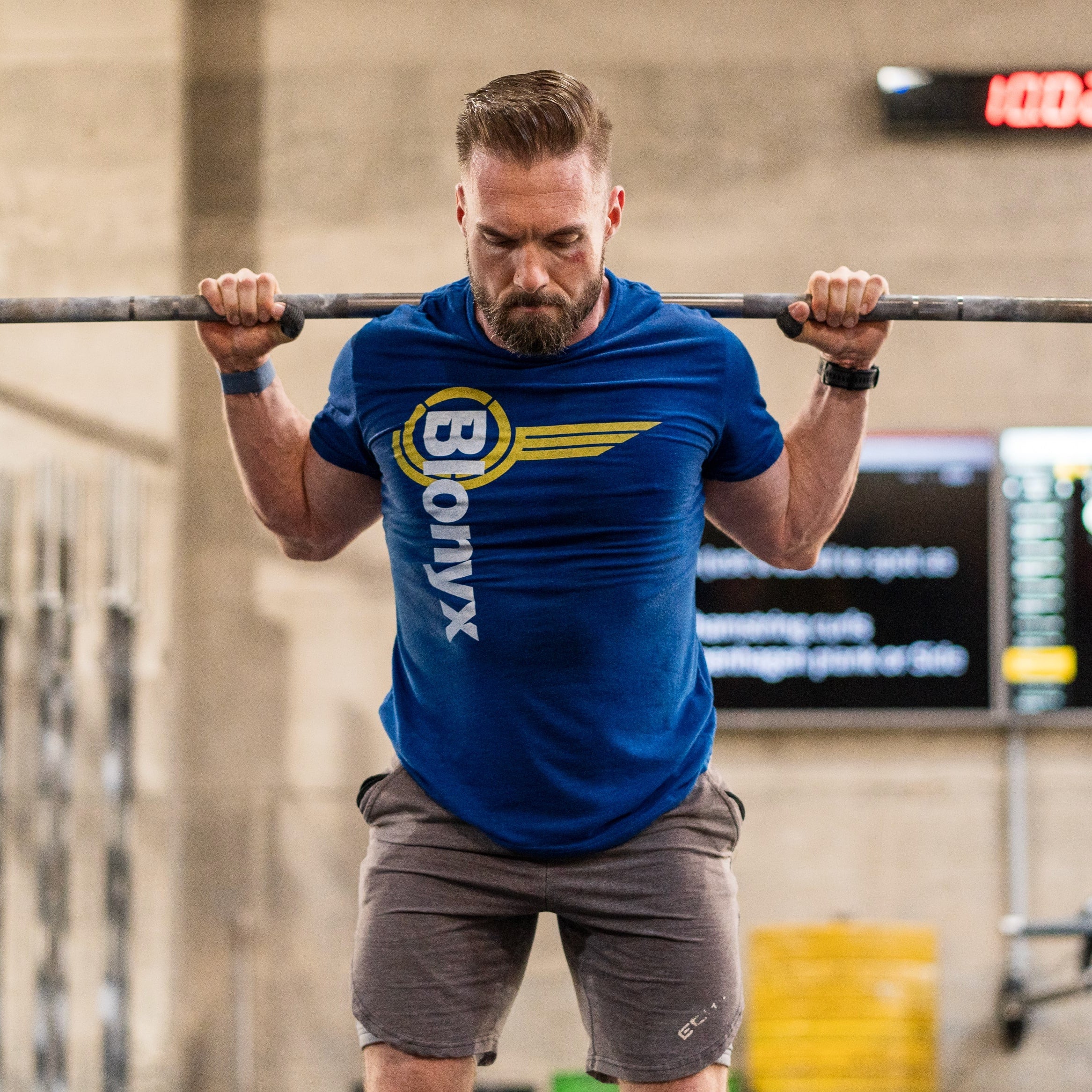 Strength athlete doing squats with a bar over their shoulders