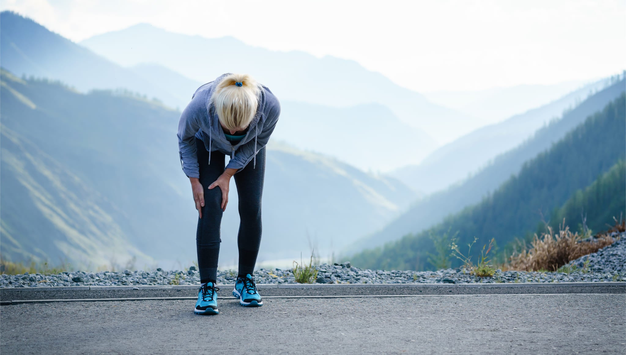 Injured athlete outdoors with mountains in the background