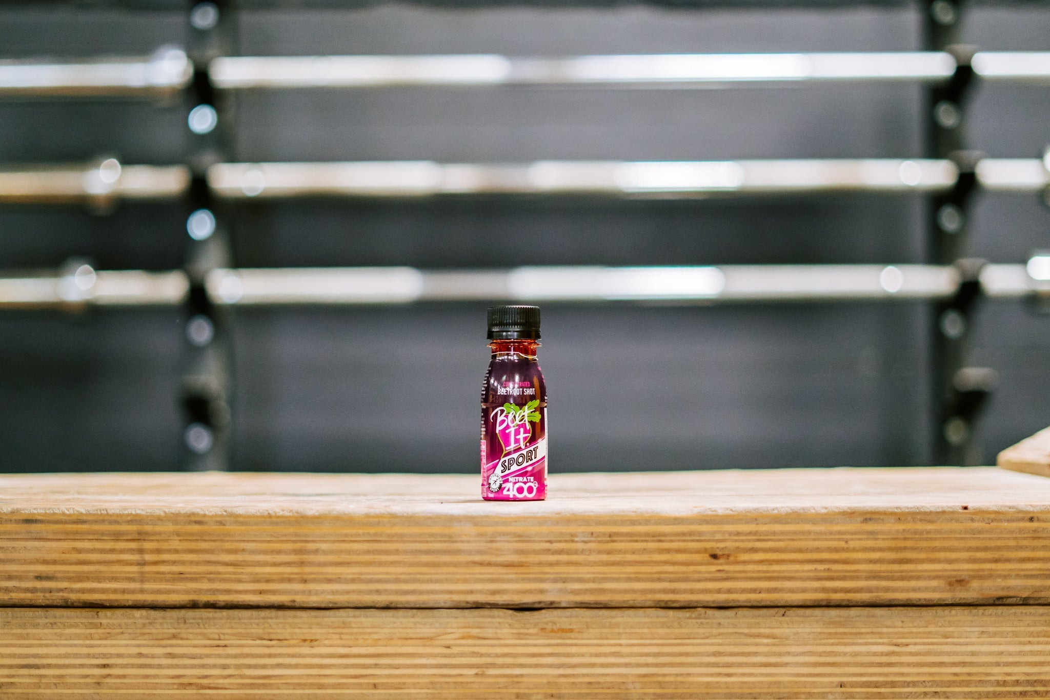 Beet It Sport Nitrate 400 shot on a wooden box in a gym