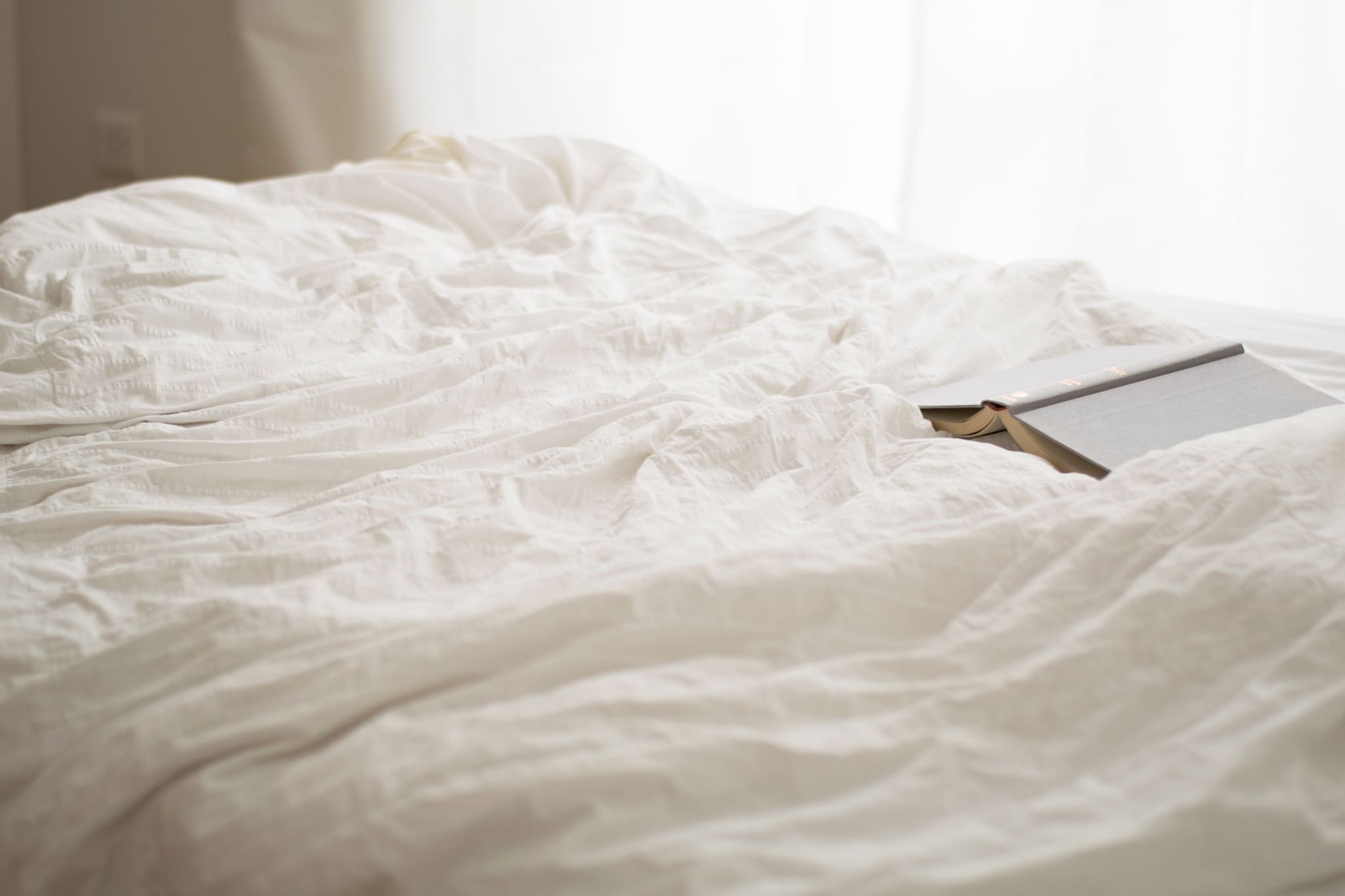 a face down book on a bed