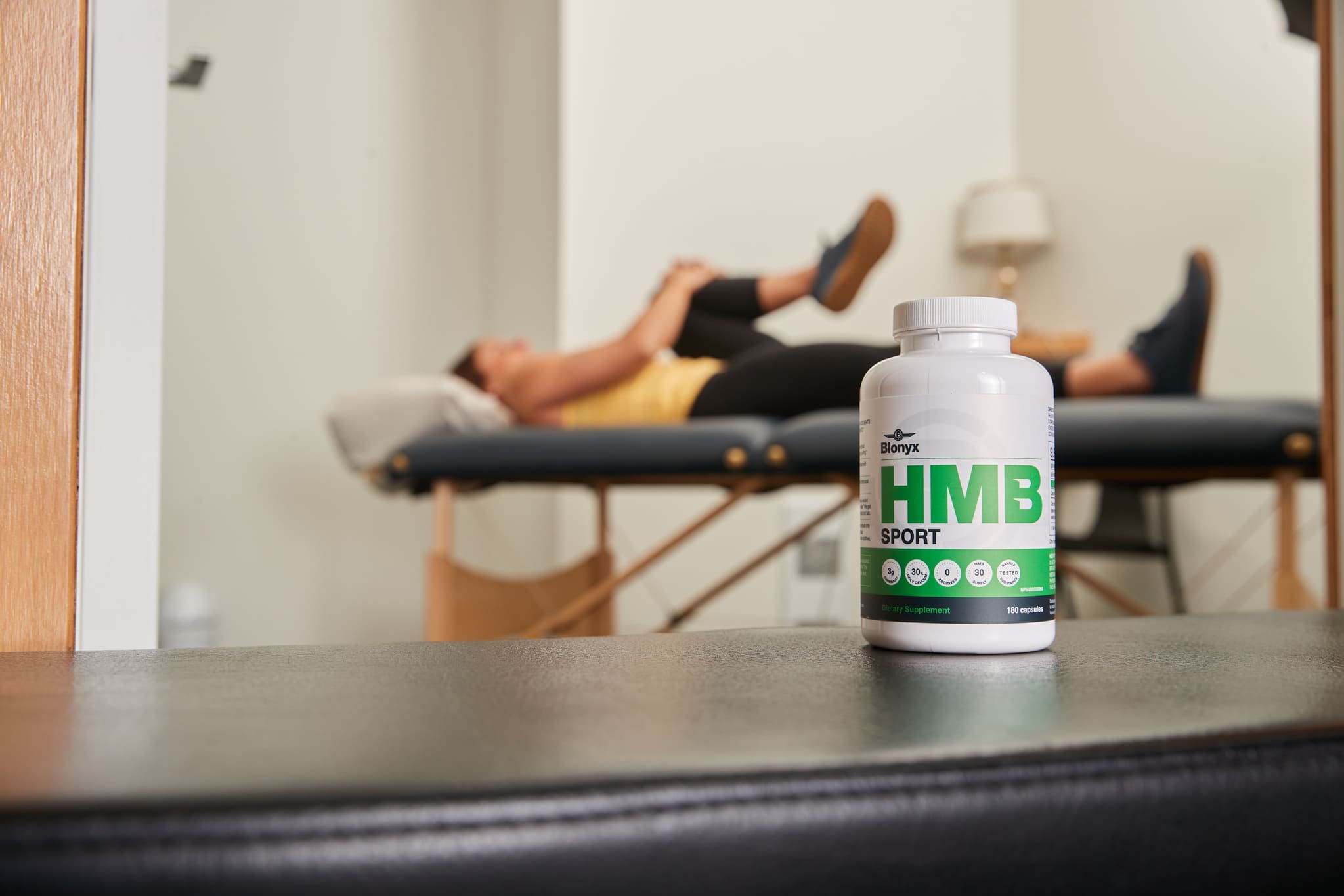 Athlete in Physio with a bottle of Blonyx HMB Sport in the foreground