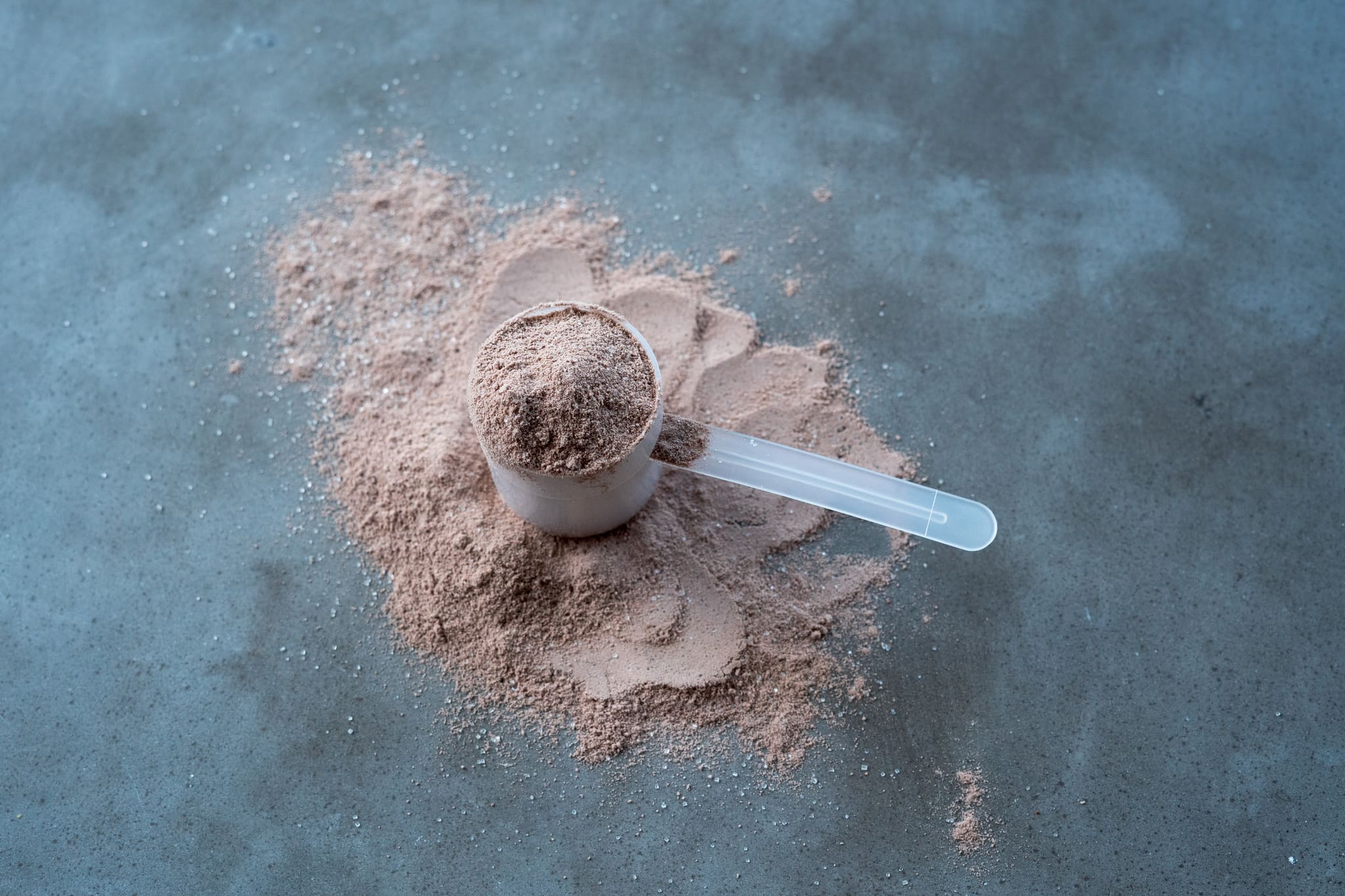 Scoop Of Egg White Protein Isolate on a Concrete Background