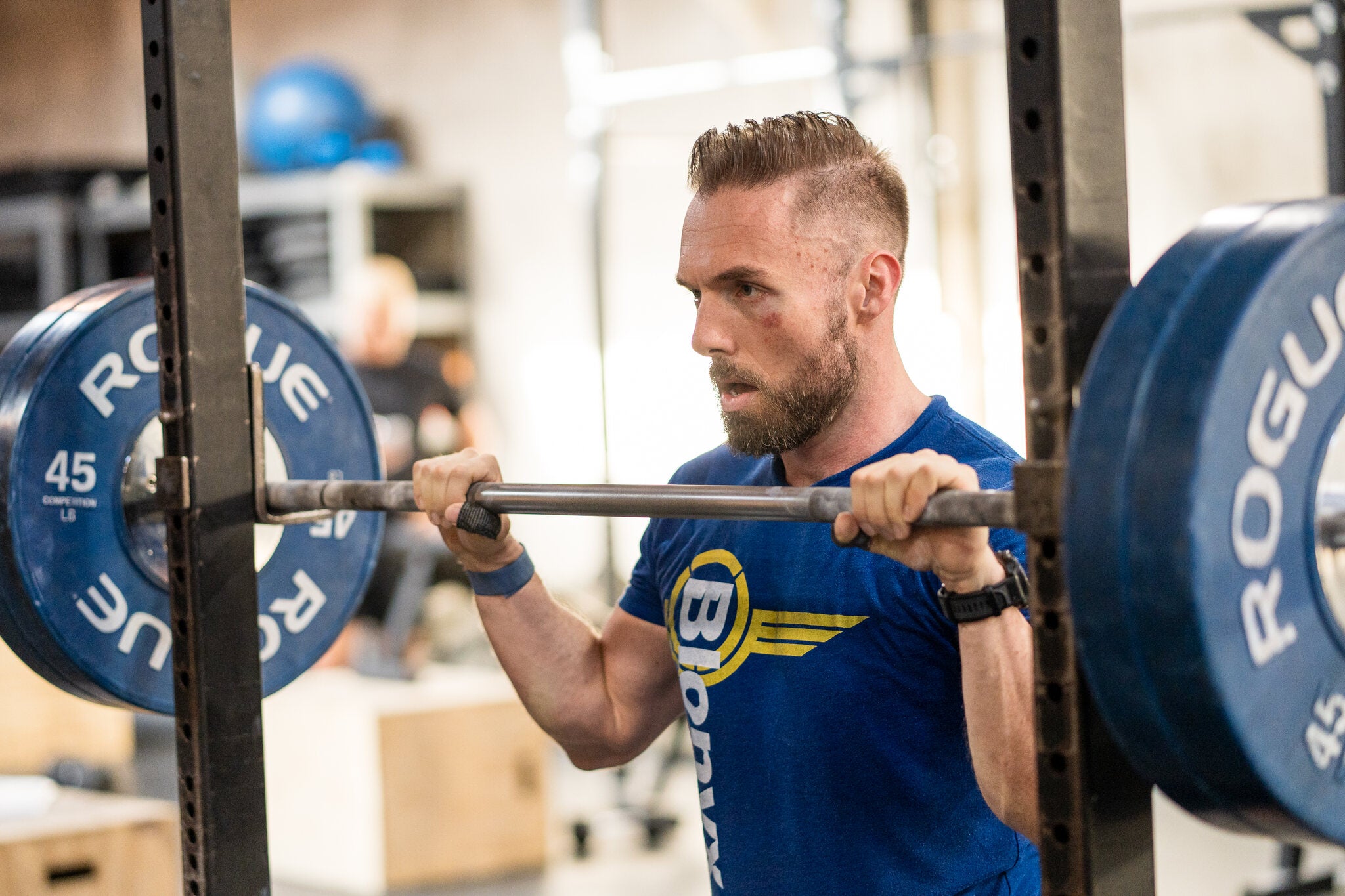 Athlete preparing to perform squats at a squat rack