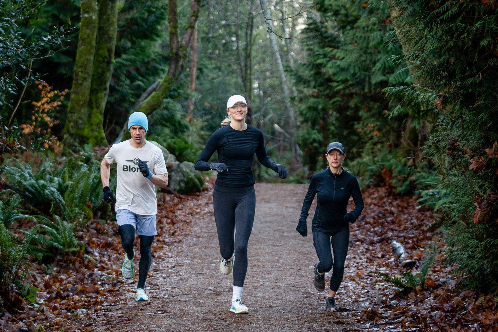 A group of three runners on a trail