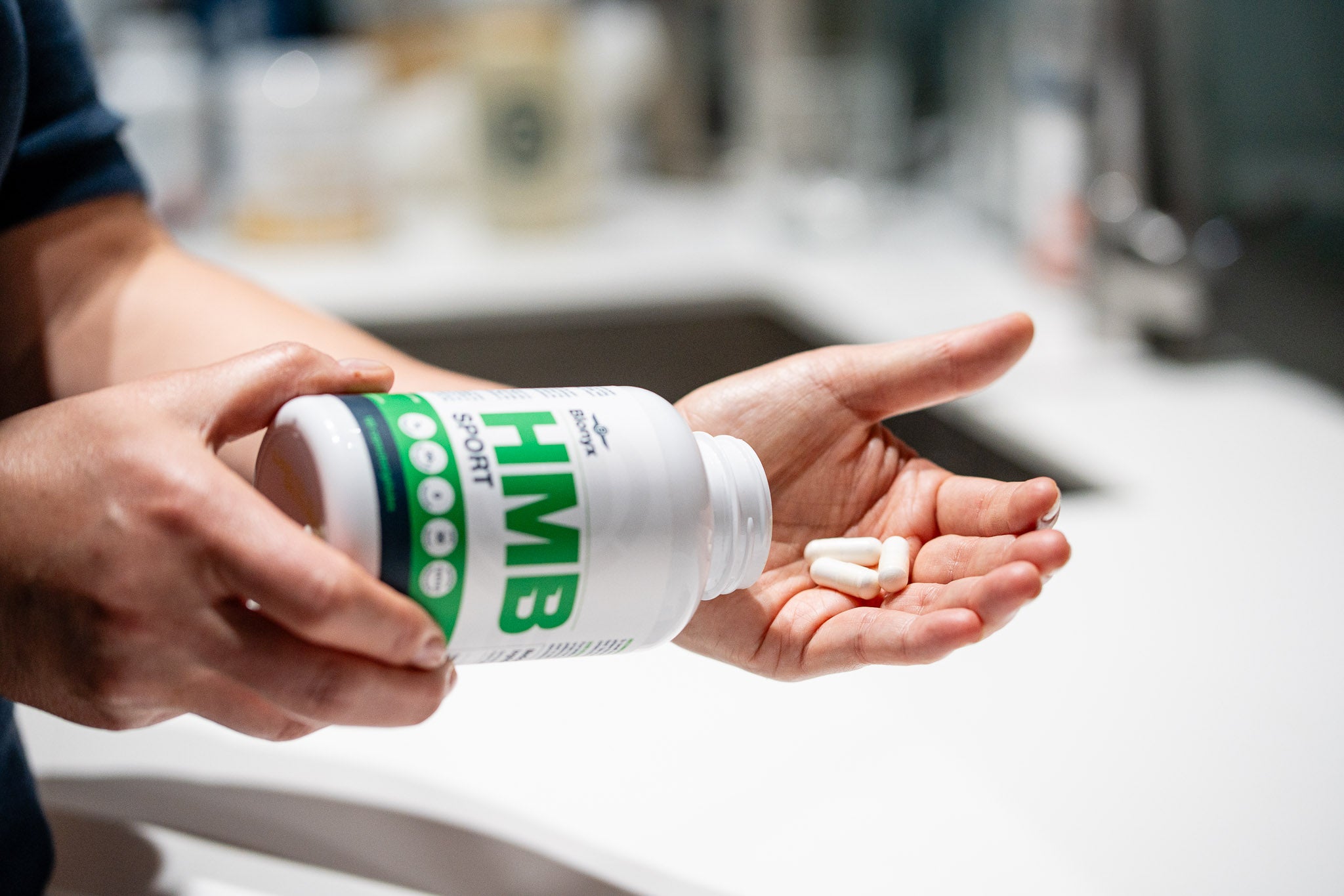 Athlete pouring Blonyx HMB Sport capsules into their hand