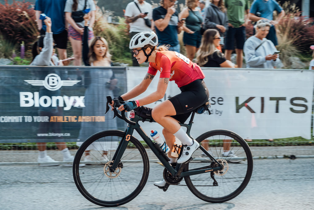 Woman riding a bike in front of a Blonyx banner