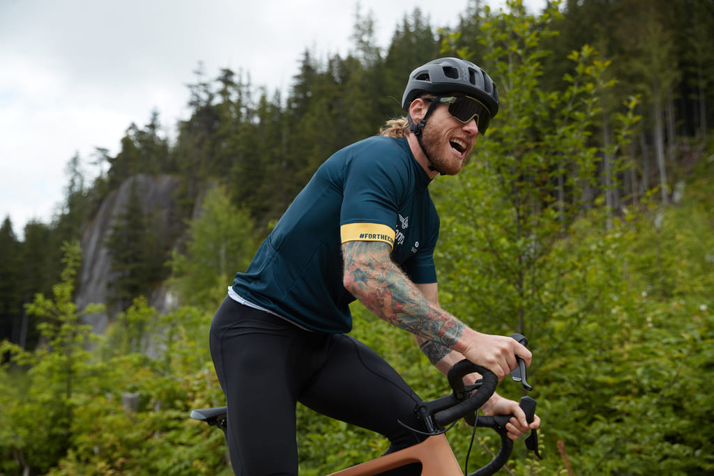 A gravel biker climbing up a wooded trail
