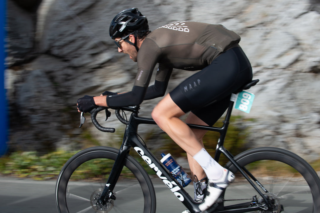 Cyclist riding a black bicycle with a blurred rocky background