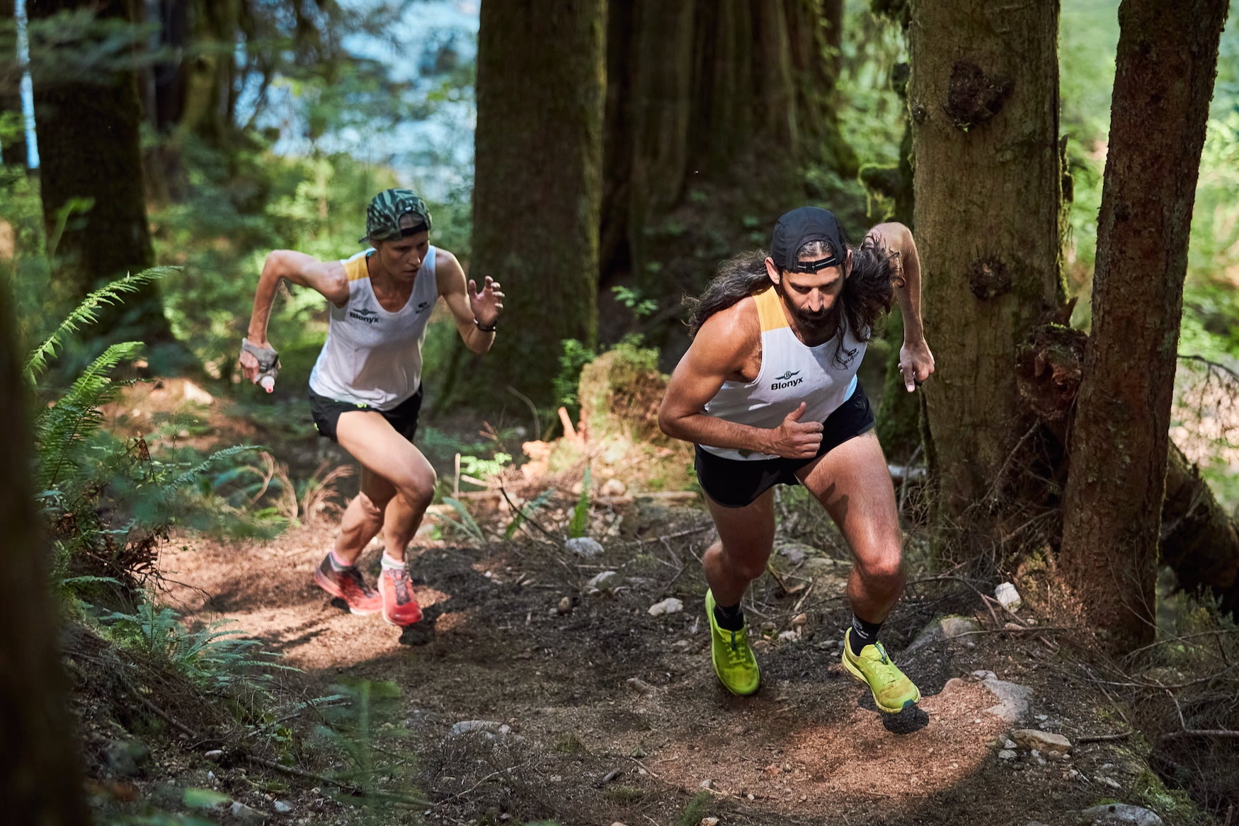 Two older trail runners powering up a trail