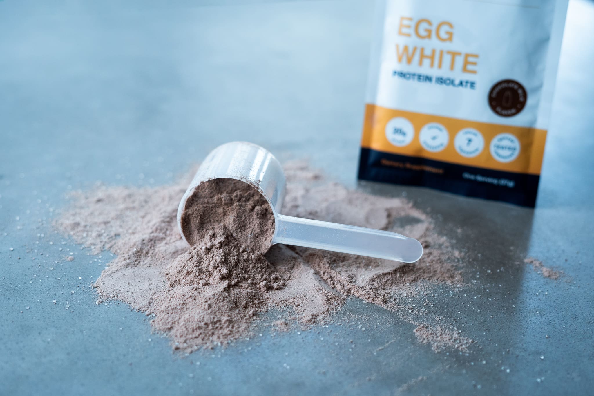 Blonyx Egg White Protein Isolate powder with a scoop and packaging on a concrete surface