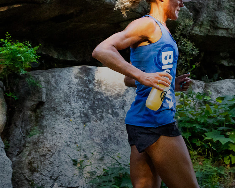 Trail runner moving along a rocky cliffside