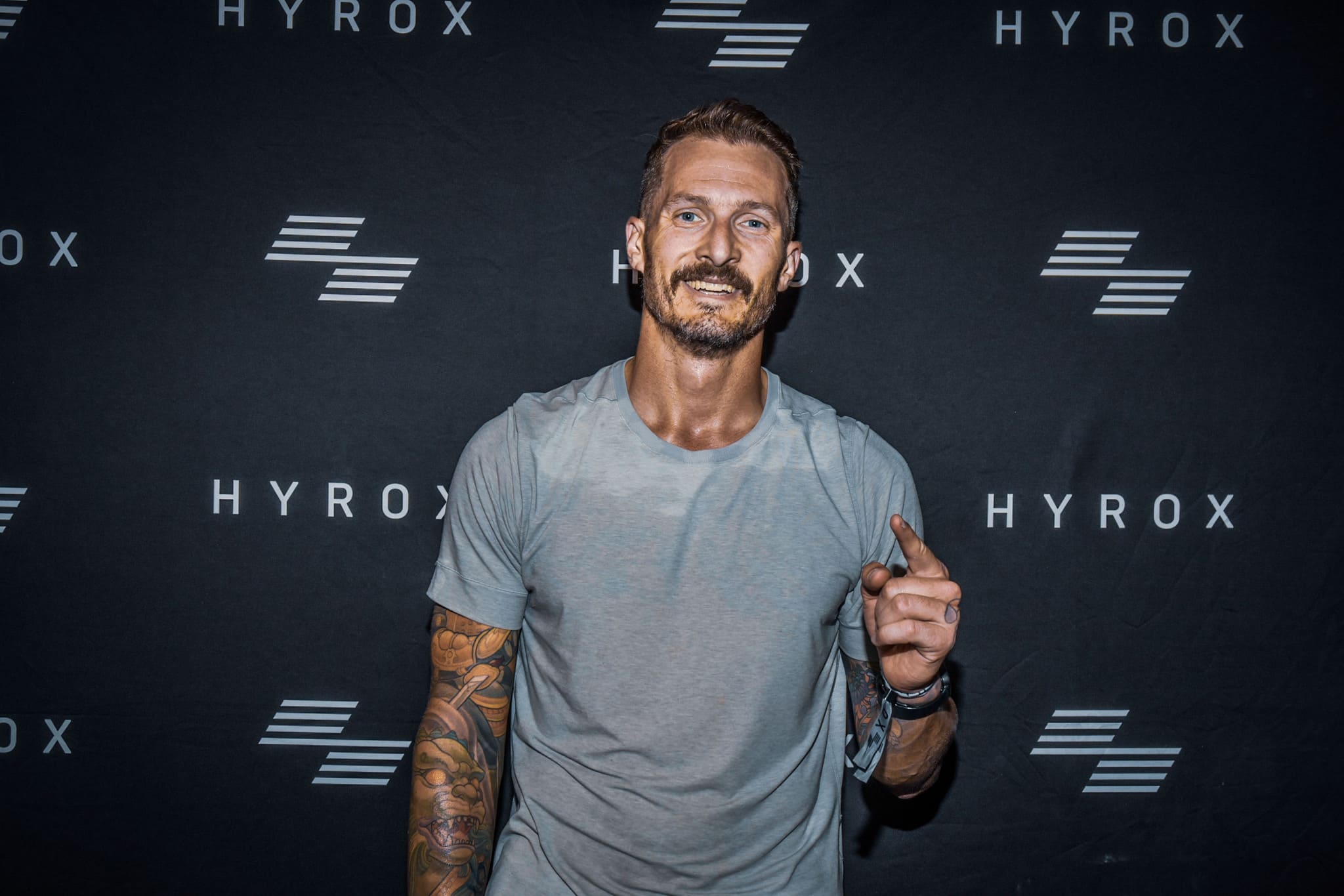 Person in cycling gear drinking from a bottle on a trail