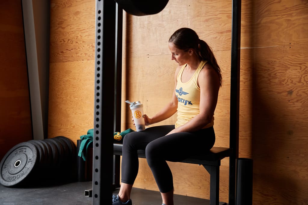 An athlete resting while holding a Blonyx shaker.