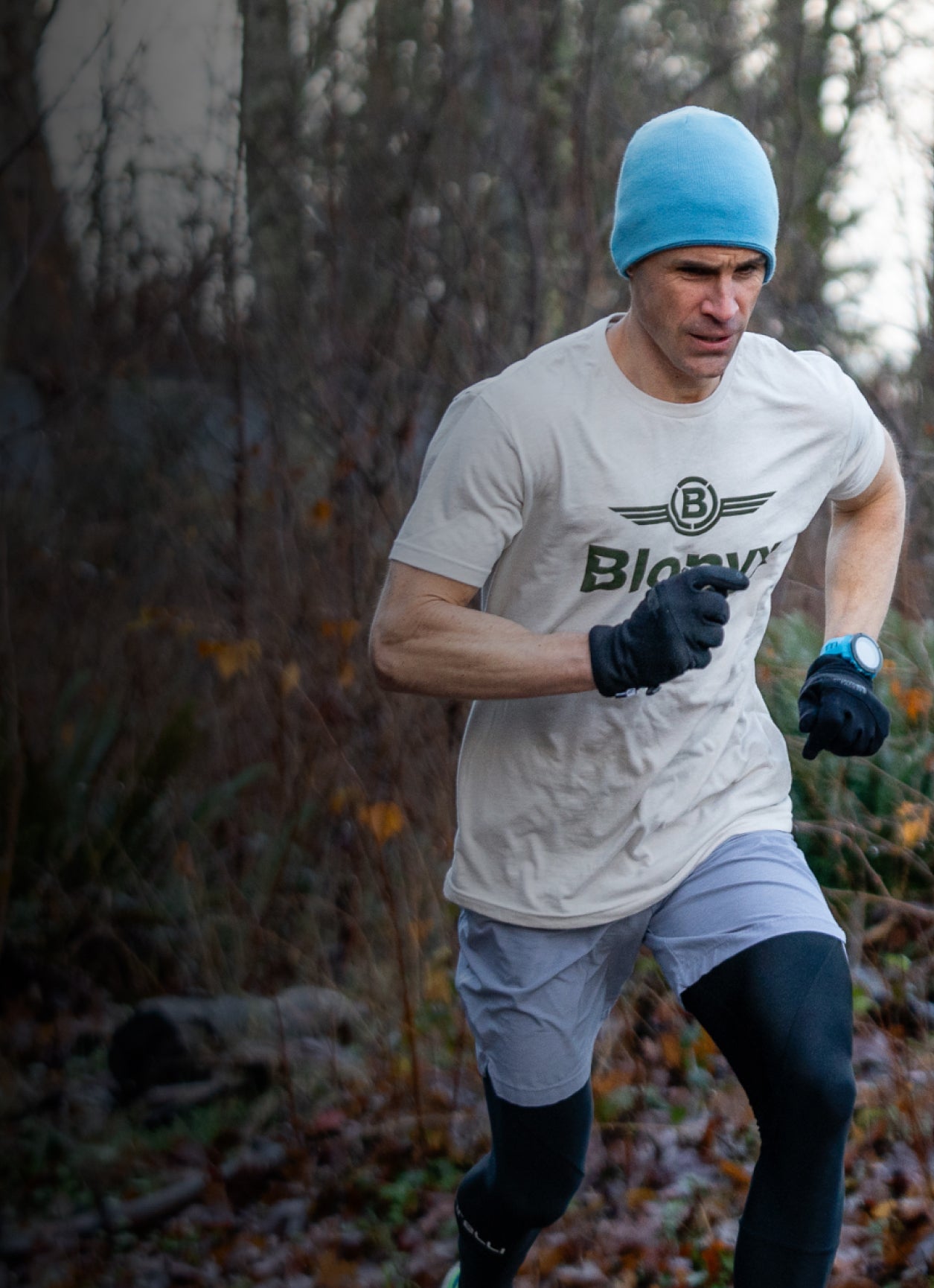 A runner wearing a Blonyx shirt and a blue hat.