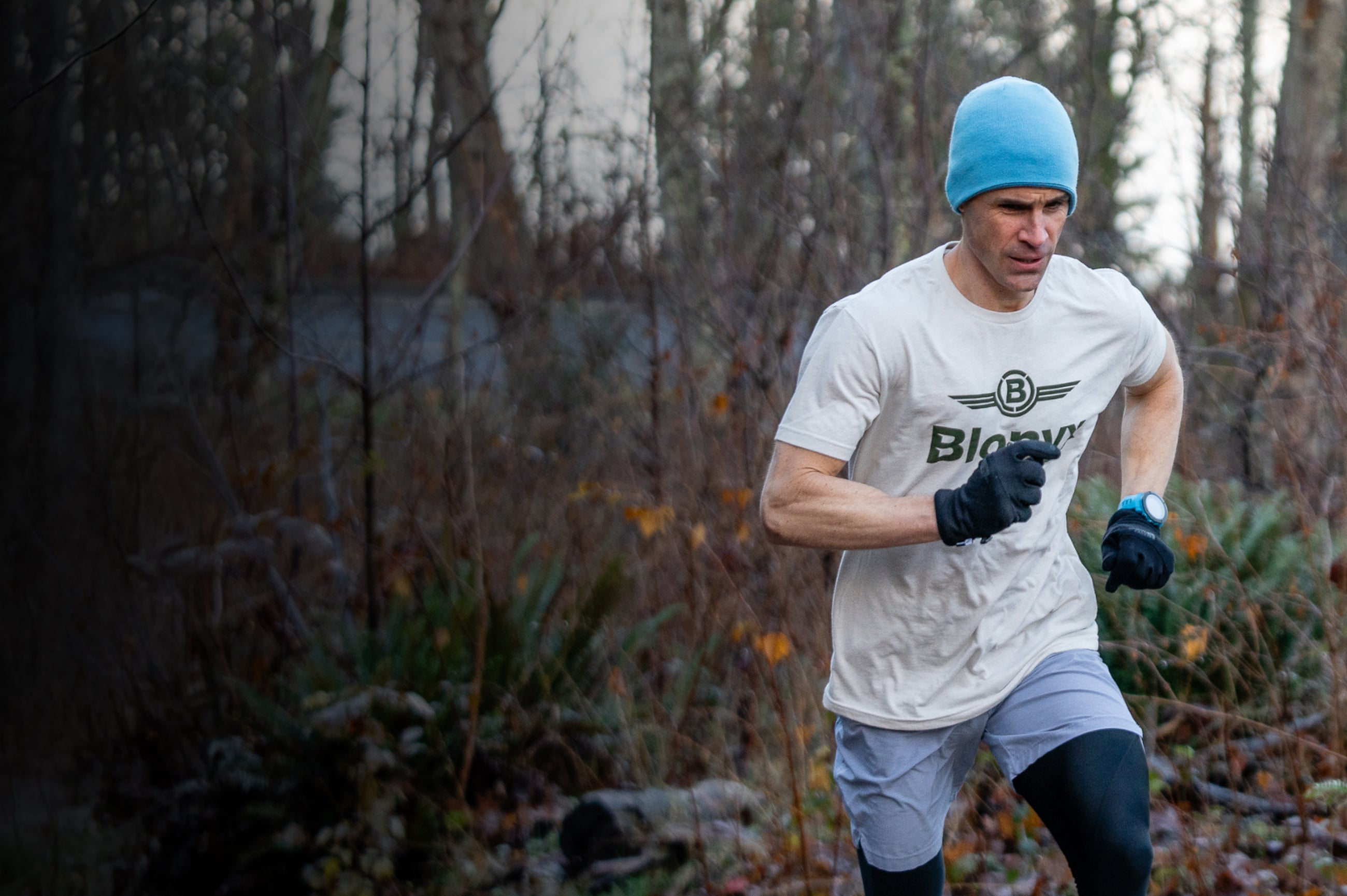 A runner wearing a Blonyx shirt and a blue hat.