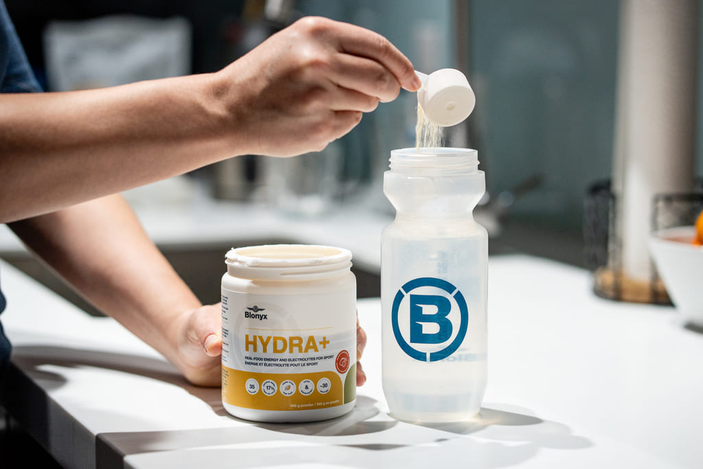 Person adding Blonyx Hydra+ to a bottle 