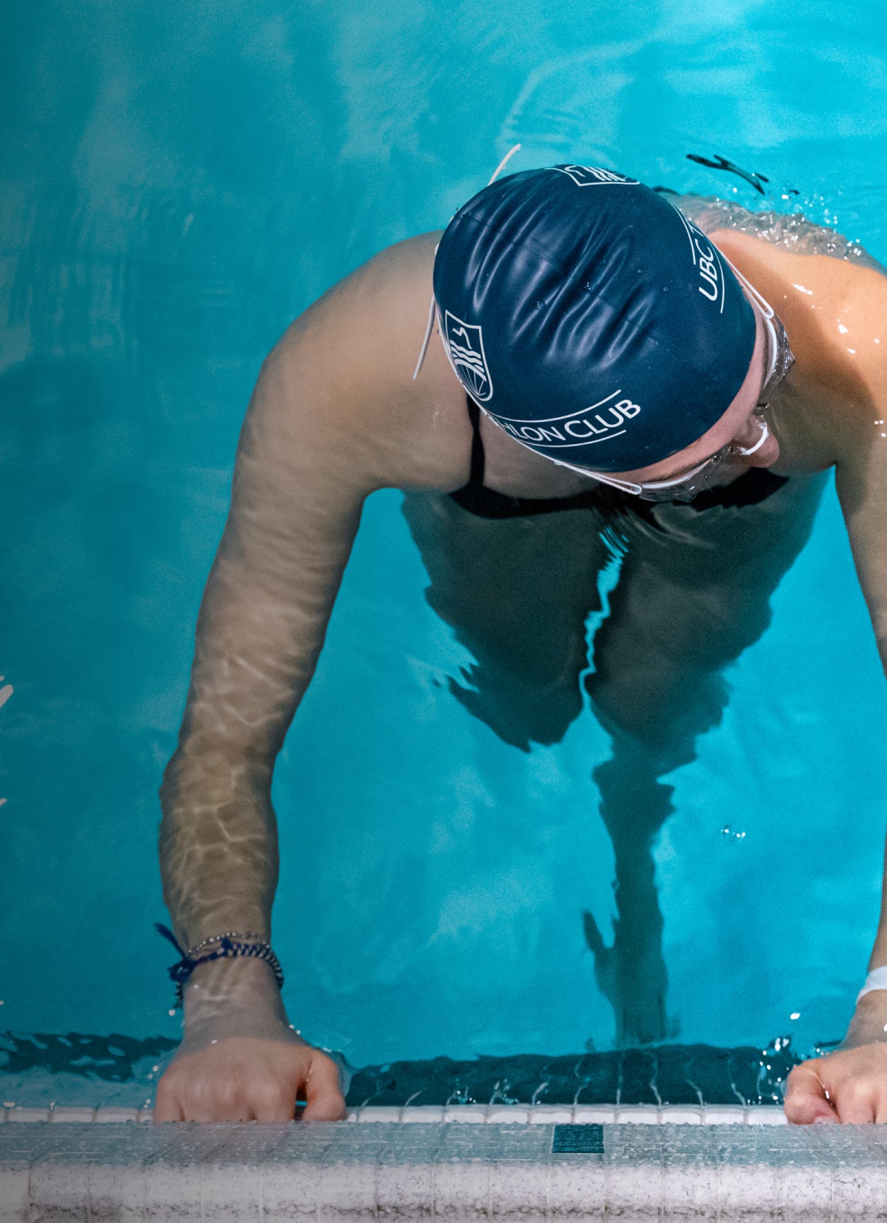 Triathlete taking a rest at the edge of a pool